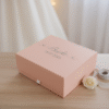 Elegantly displayed pink custom gift box for a bride, featuring "Bride" and the wedding date "18.07.2026" on the lid, perfect for bridal shower gifts or wedding morning preparations.