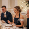 Smiling bride at wedding top table wearing a personalised navy 'Mrs. Griffiths 31.08.24' apron with rose gold rings design, celebrating her wedding meal. Ideal for bridal gifts, wedding day accessories, and personalised bride aprons.