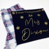 Personalised First Christmas short pyjamas with married name and gold snowflake design, folded with pink and blue check shorts – festive newlywed gift.