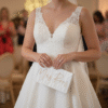 Close up of a bride holding a personalised white "Mrs Rees" wedding clutch bag at a relaxed evening reception, perfect for bridal accessories.